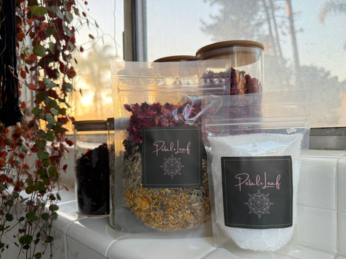 Packets of dried herbs and a container labeled 'Pearl Leaf' on a windowsill with natural light.